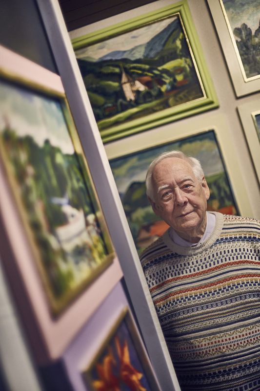 Helmut Schneider vor einer Wand mit eigenen Bildern – sie zeigen sein liebstes Motiv: Straßburg und das nahe Elsass.