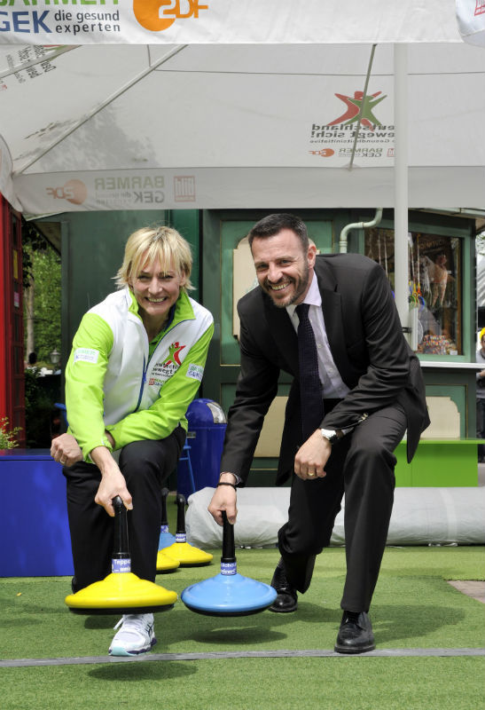Heike Drechsler und Dirk Fischbach üben sich im Teppichcurling.