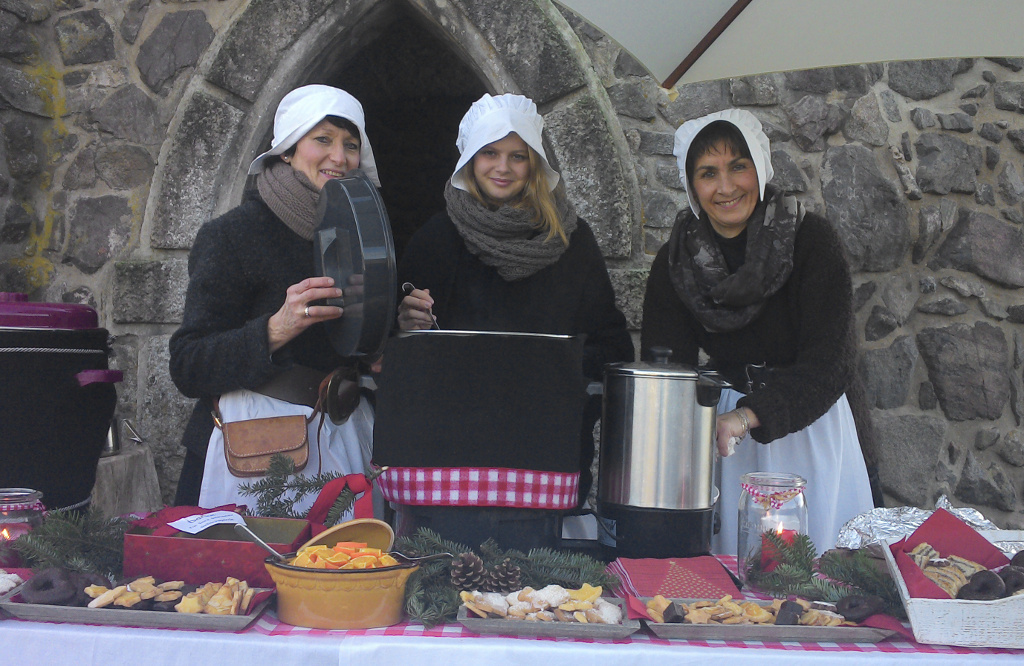 Die Burgmägde bewirten die Gäste mit Glühwein, Punsch und Weihnachtsgebäck.