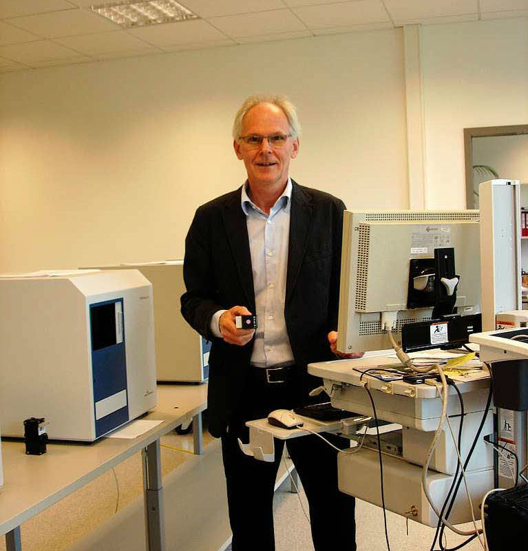 Geschäftsführer Thomas Räbiger inmitten der Mikroplatten-Lesegeräte.