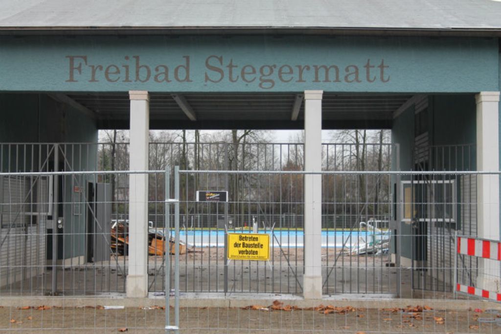 Abbruchstimmung: Der Bauzaun entlang der Stegermattstraße und der erste Bauschutt auf dem Gelände des Freibads zeugen vom Beginn der Arbeiten für das neue Freizeitbad.
