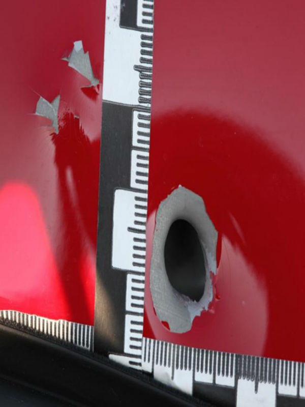 Einschussloch Kaliber neun Millimeter an einem Pkw.