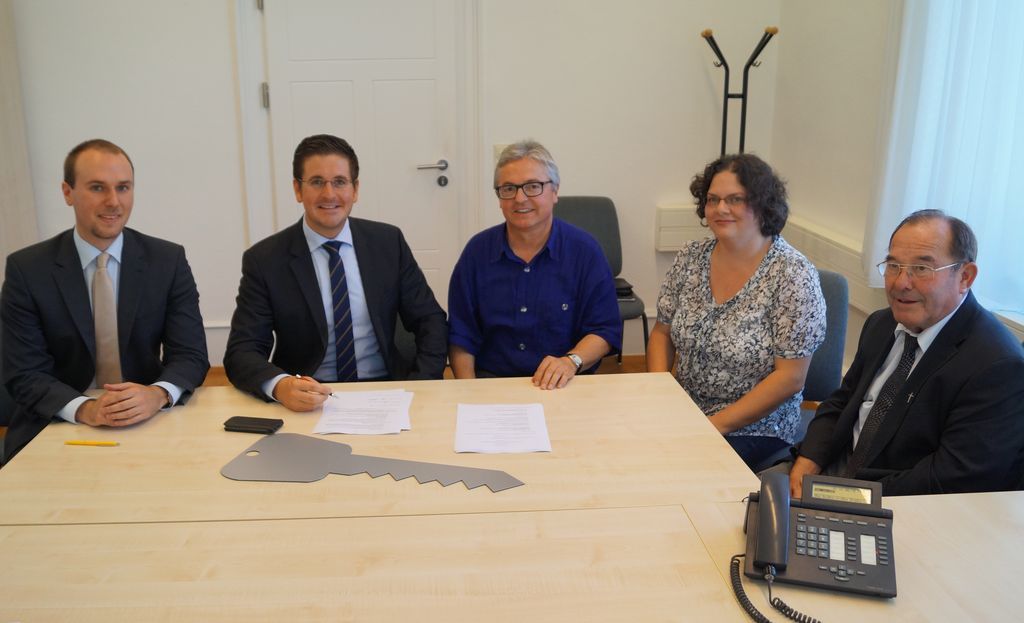 Unterzeichnung des Kaufvertrags (von links): Notar Jens Rohrer, Bürgermeister Stefan Hattenbach, Pfarrer Georg Schmitt, Stiftungsrätin Claudia Baßler, Pfarrer a.D. Wendelin Faller.
