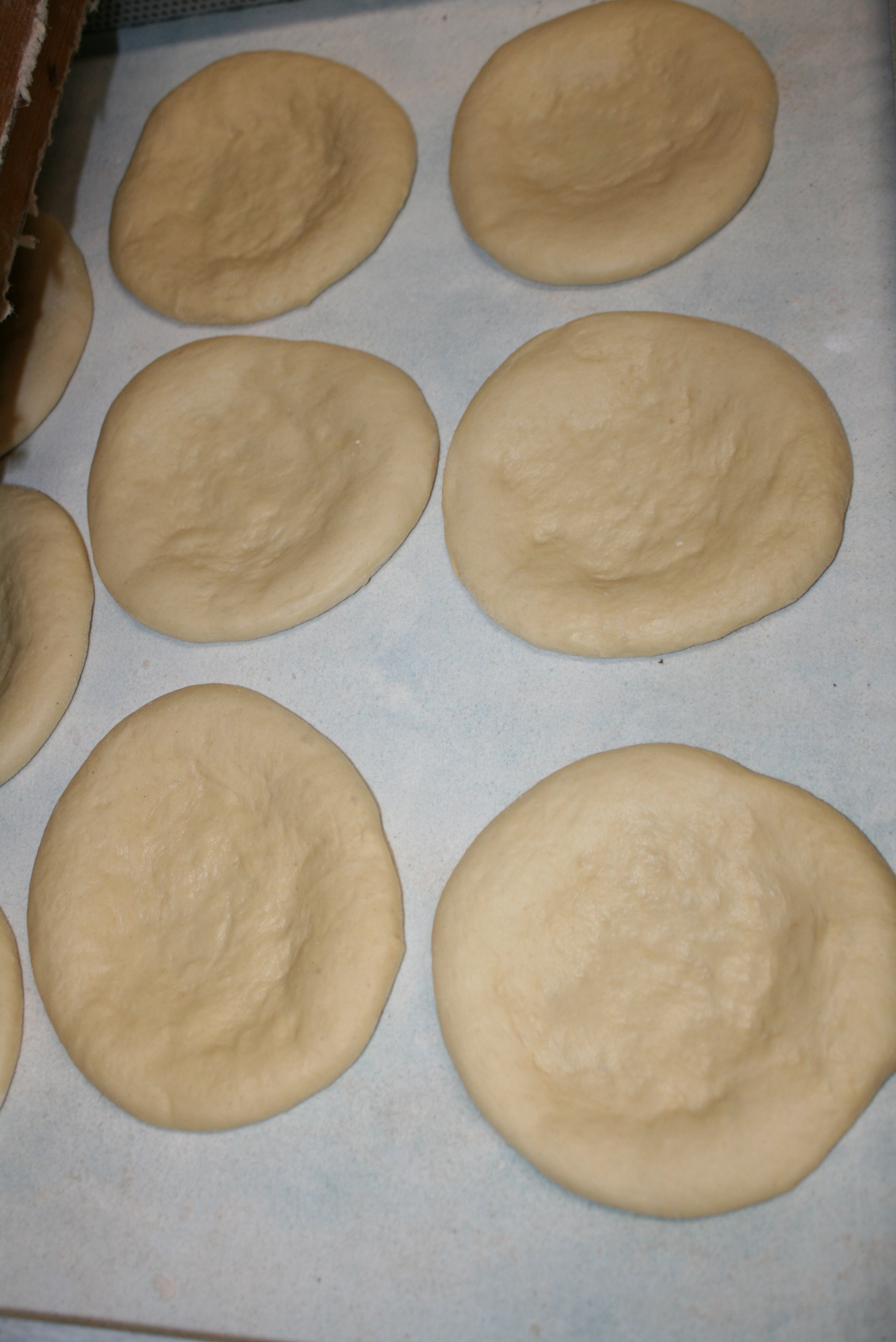 Faschingsküchlein bevor sie gebacken wurden. Durch das Ausziehen des Teiges sind sie in der Mitte hauchdünn.
