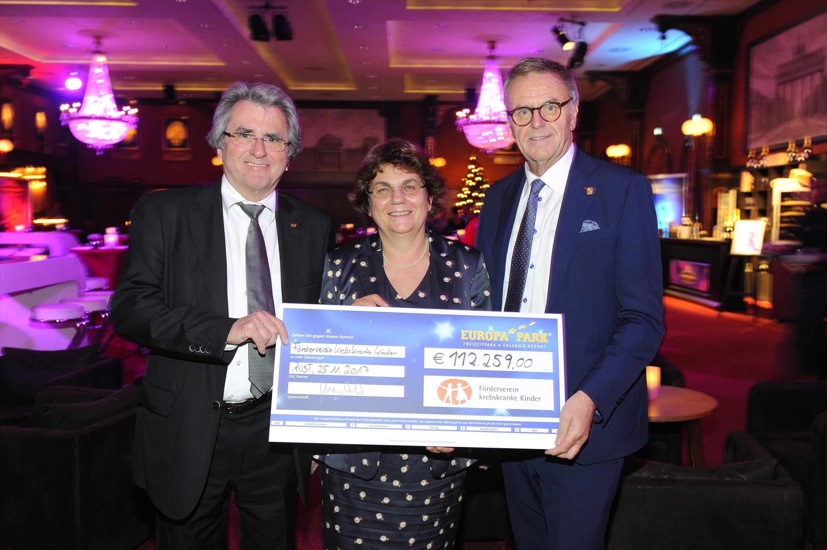 Werner Kimmig (links) und Roland Mack (rechts) überreichen Prof. Dr. Charlotte Niemeyer den Scheck. Foto: Europa-Park