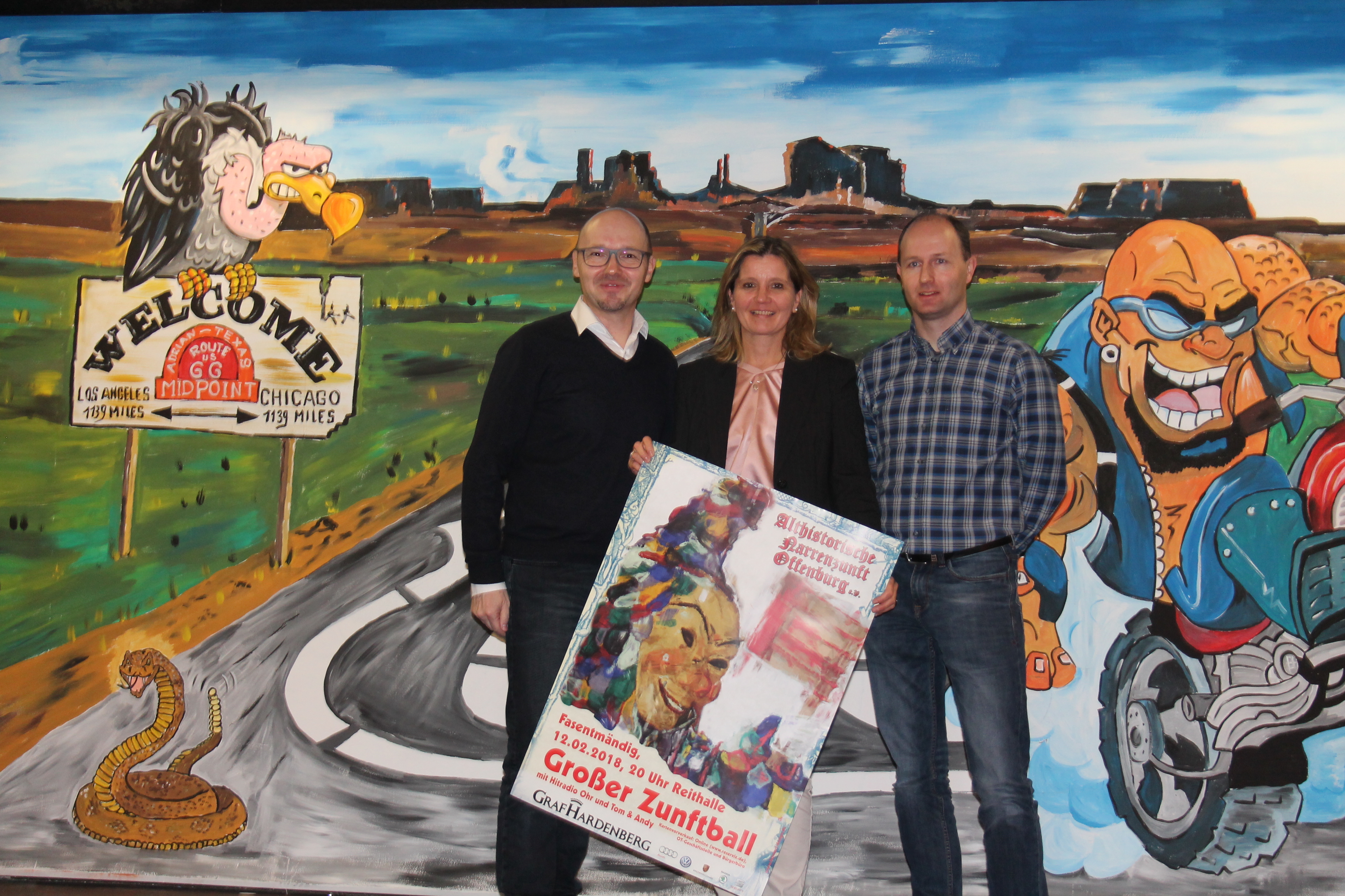 Zunftmeister Thomas Decker (v.l.) mit den beiden Narrenräten Martina Benz und Mike Harter vor der Kellerabend-Kulisse "Route 66"