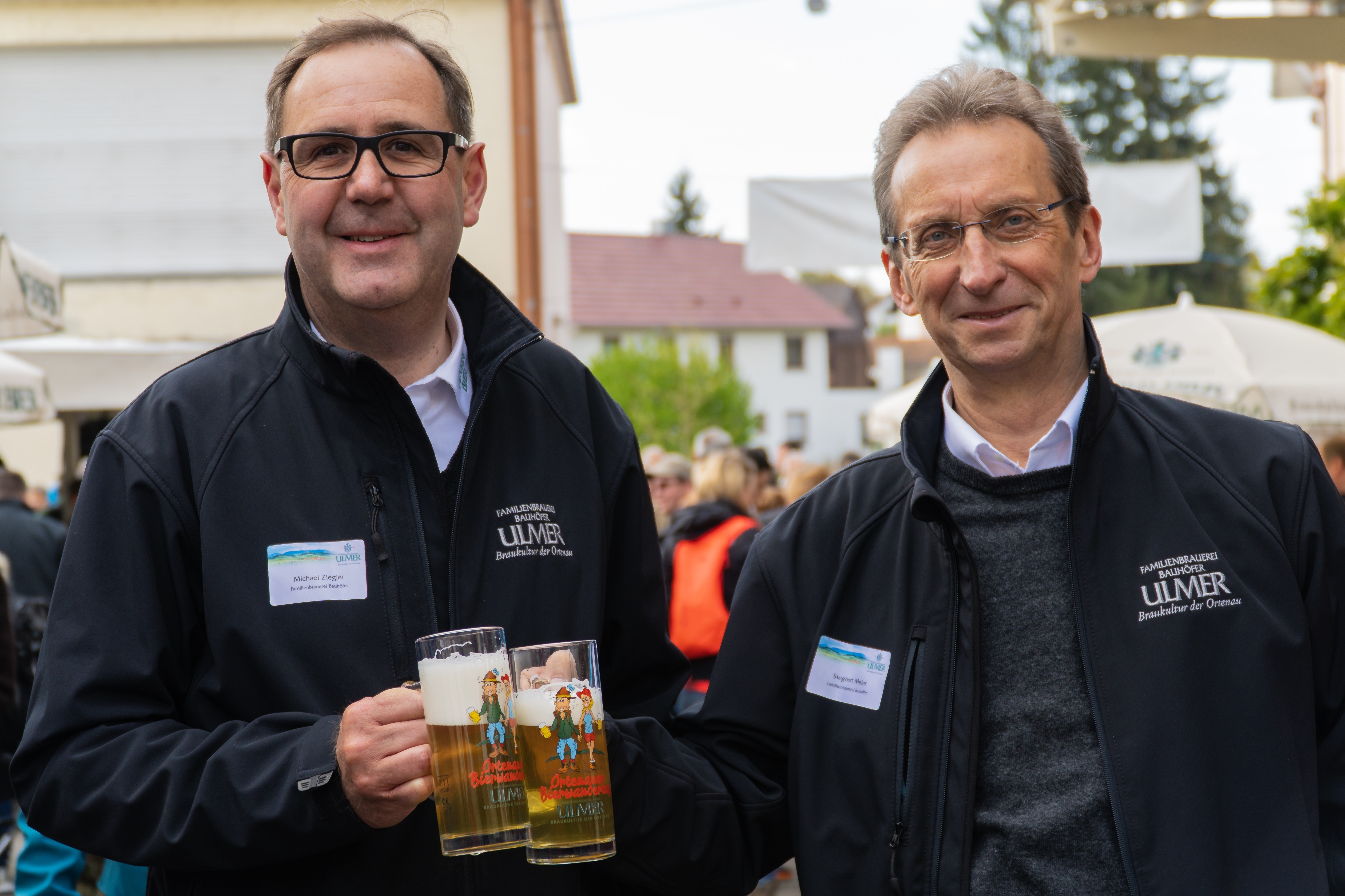 Geschäftsführer Siegbert Meier (r.) und Prokurist Michael Ziegler präsentieren die aktuellen Krüge, die alle inklusive zweier Bierproben erhalten, die den Wanderpass erwerben.