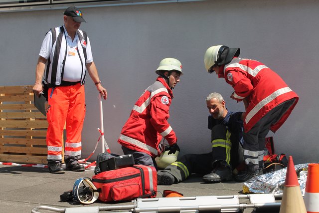 Einem Feuerwehrmann in Not wird geholfen.
