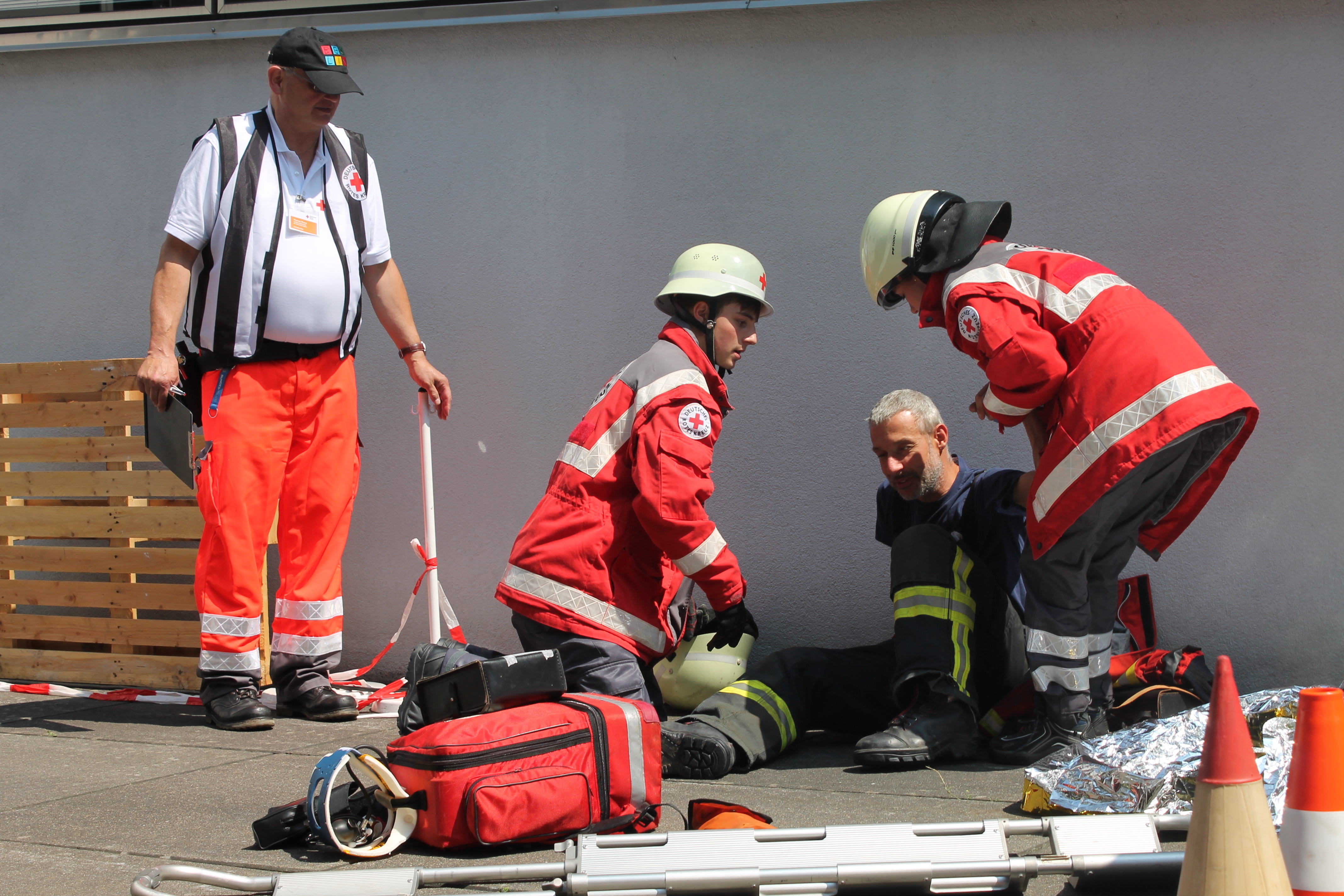 Einem Feuerwehrmann in Not wird geholfen.