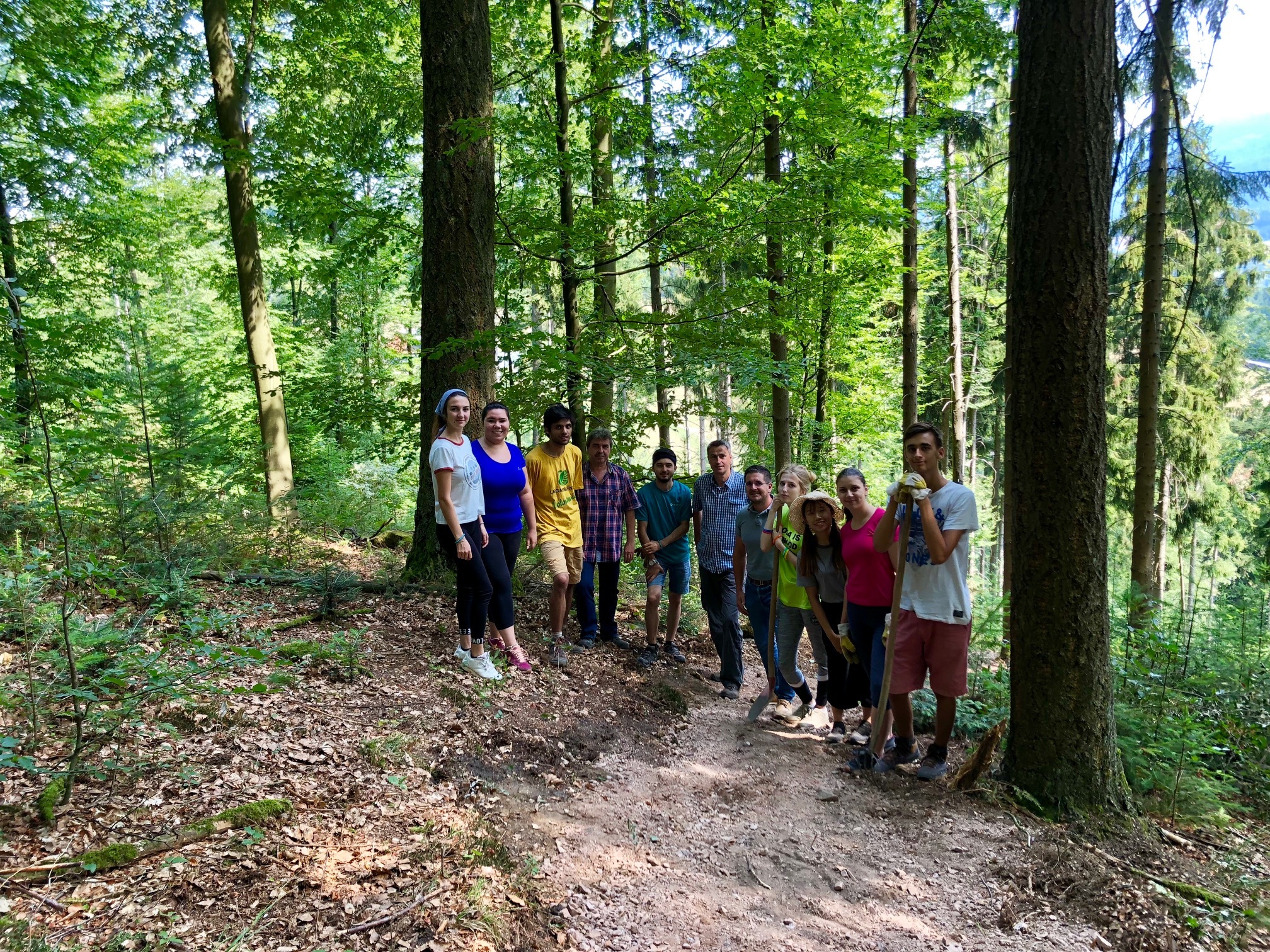 Die bunte Truppe des internationalen Workcamps auf einem von den Freiwilligen neu gebauten Wanderweg, der auch für den projektierten tälerübergreifenden Hexensteig benötigt wird. Mit dabei Bauamtsleiter Paul Huber, Revierleiter Theo Blaich, und Bürgermeister Stefan Hattenbach