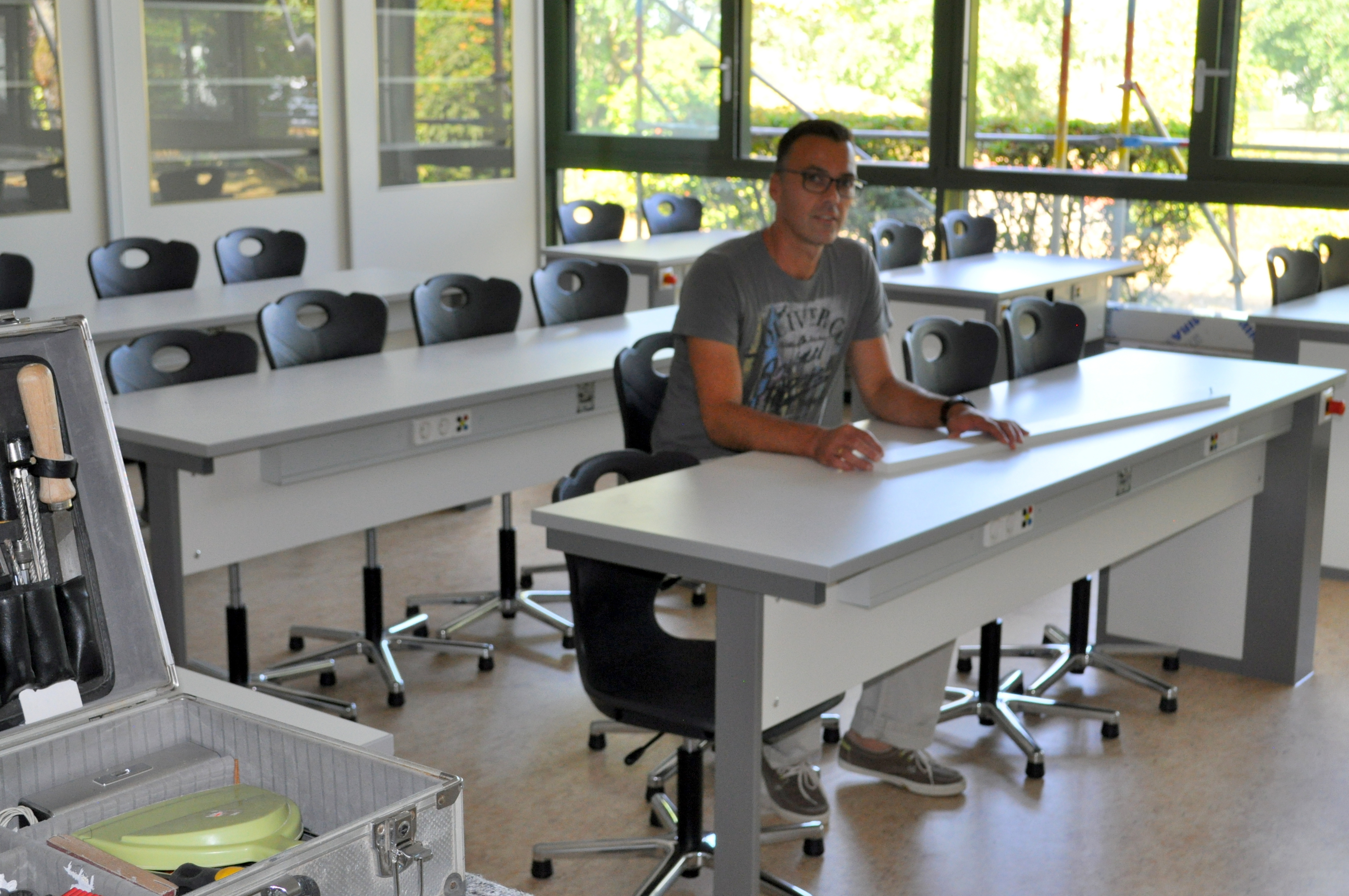 Der städtische Projektleiter Jürgen Bürk an den neuen Möbeln im Gymnasium.