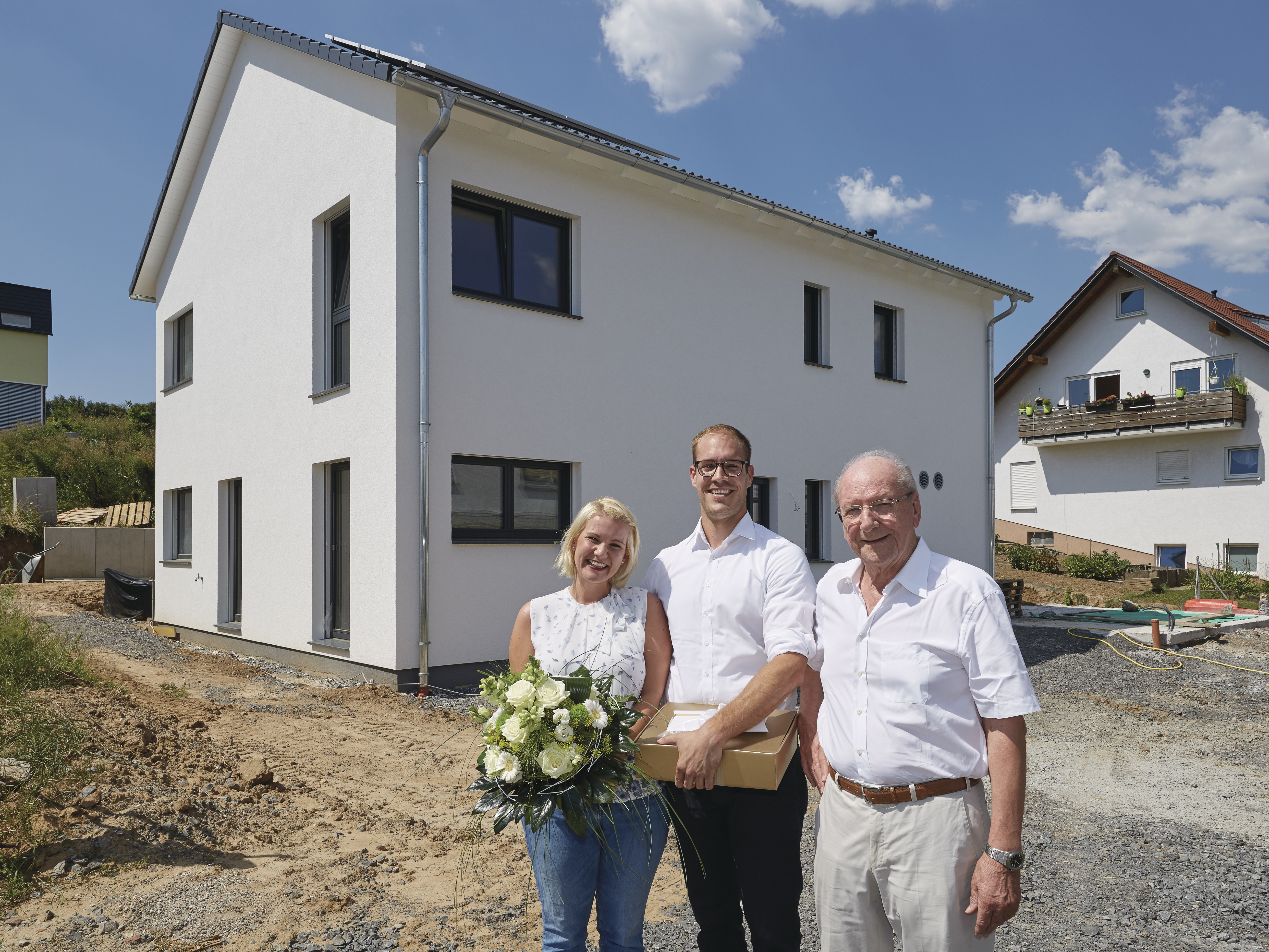 Hans Weber (r.) gratuliert dem Ehepaar des 36.000. Weber-Hauses.