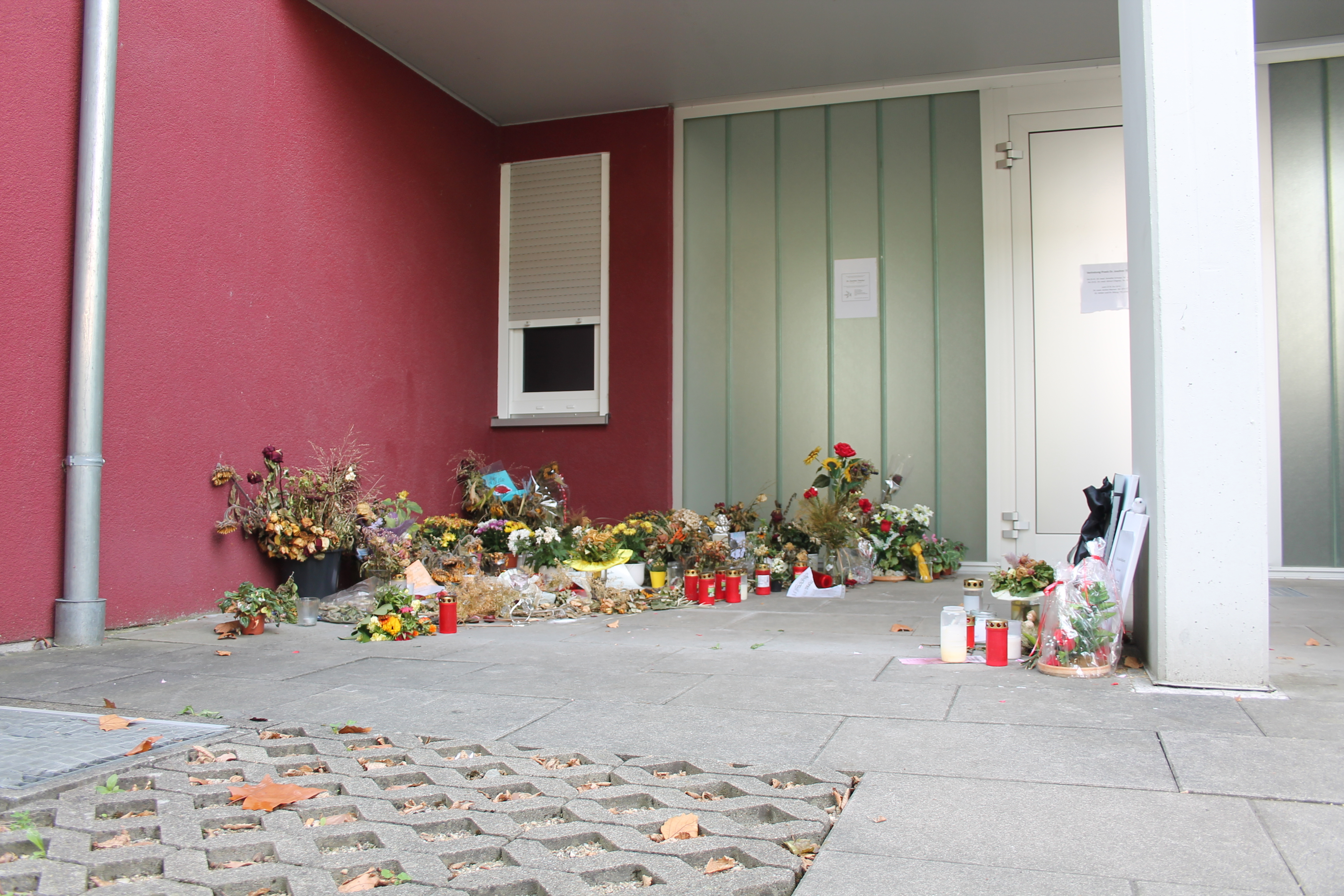 Auch einen Monat nach der Tat liegen Blumen und Kondolenzschreiben vor der ehemaligen Hausarztpraxis.