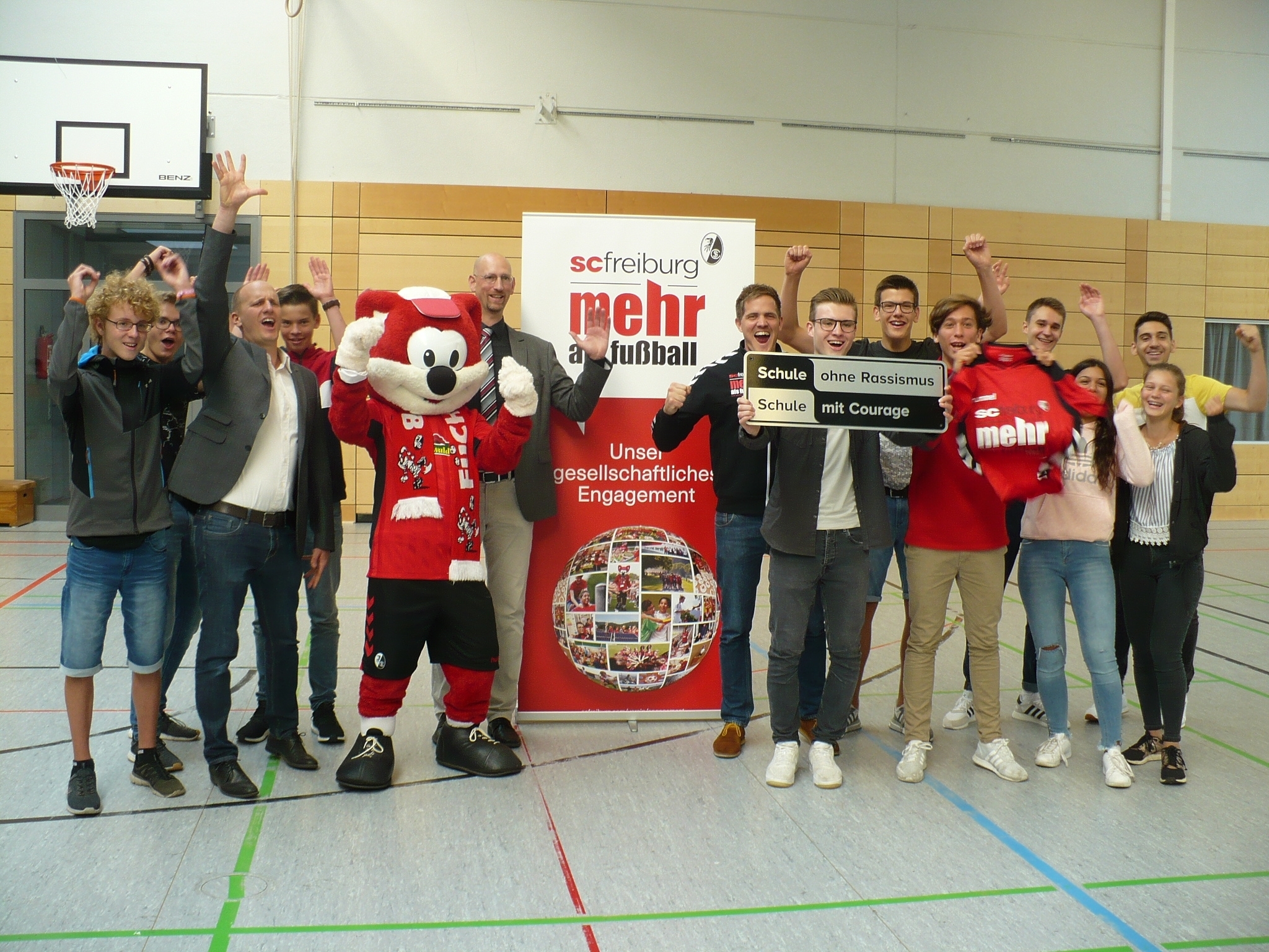 Große Freude bei der Titelübergabe: Schüler aus dem Arbeitskreis "Schule ohne Rassismus", Niklas Ziegler vom SC Freiburg, Schulleiter Stefan Feld und Stellvertreter Aiko Schuhmann.