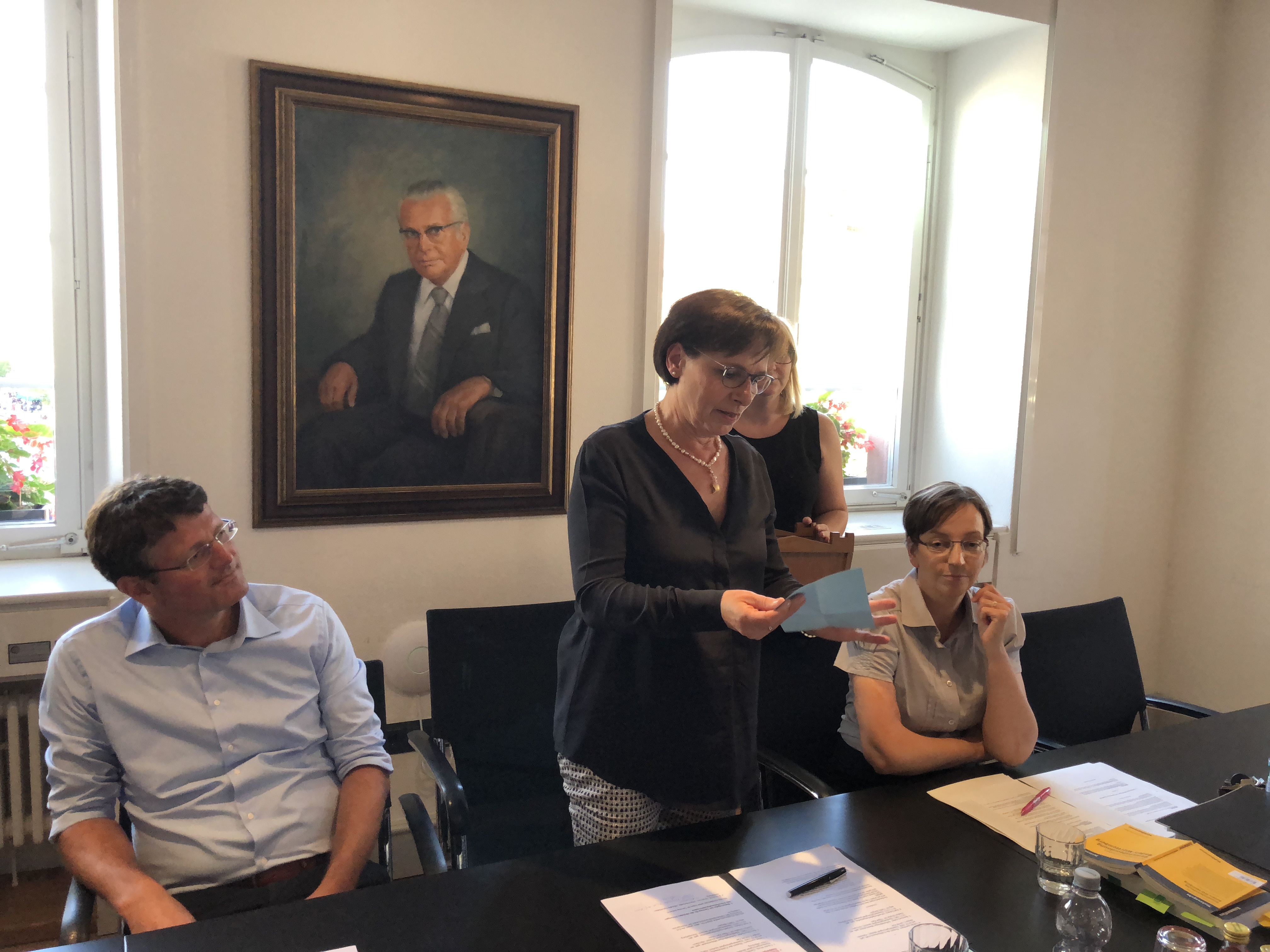 Oberbürgermeisterin Edith Schreiner (Mitte) zieht im Gemeindewahlausschuss per Los, welcher Kandidat oben auf dem Stimmzettel steht.