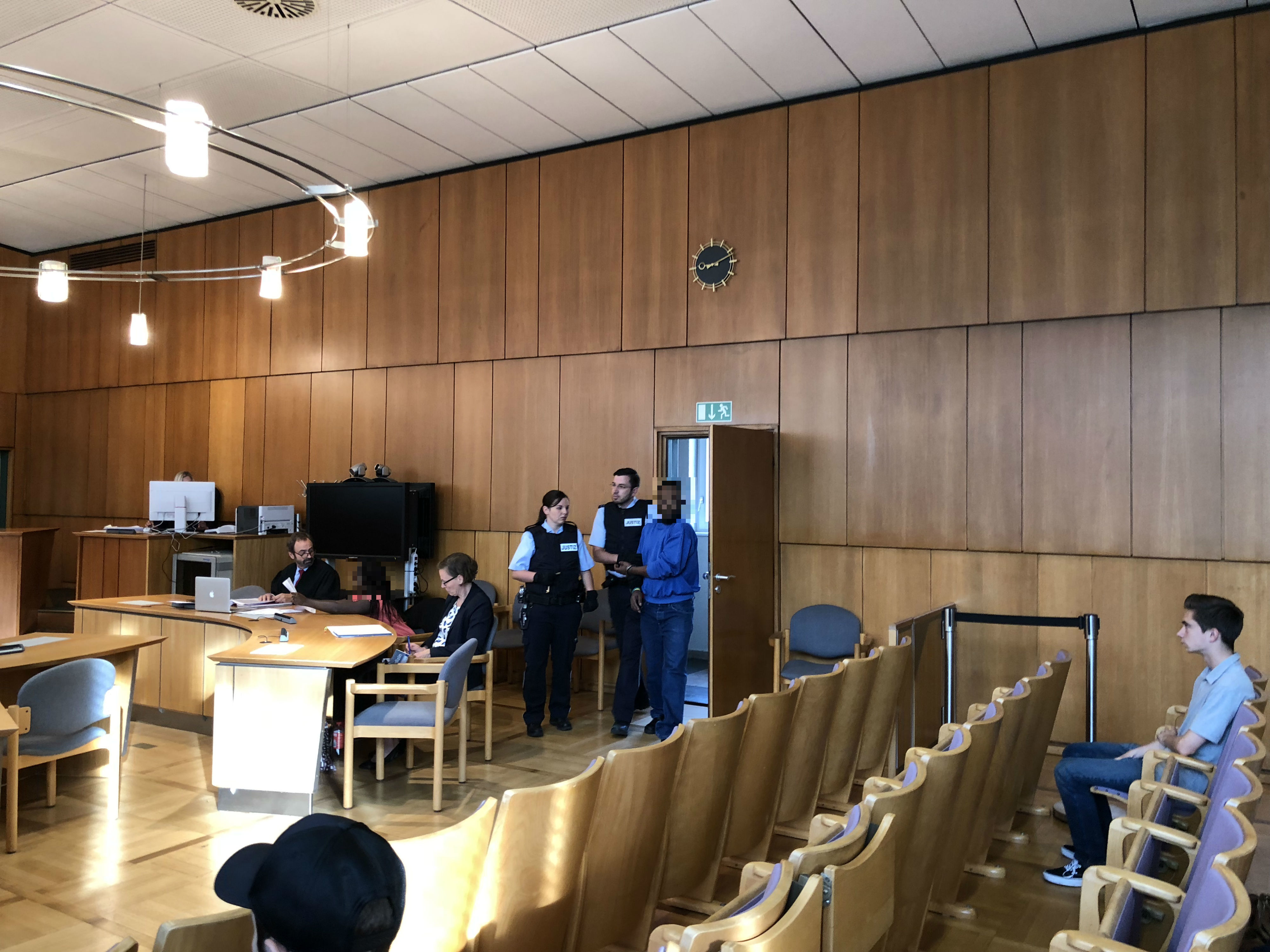 Der Gefangene wird in den Gerichtssaal geführt.