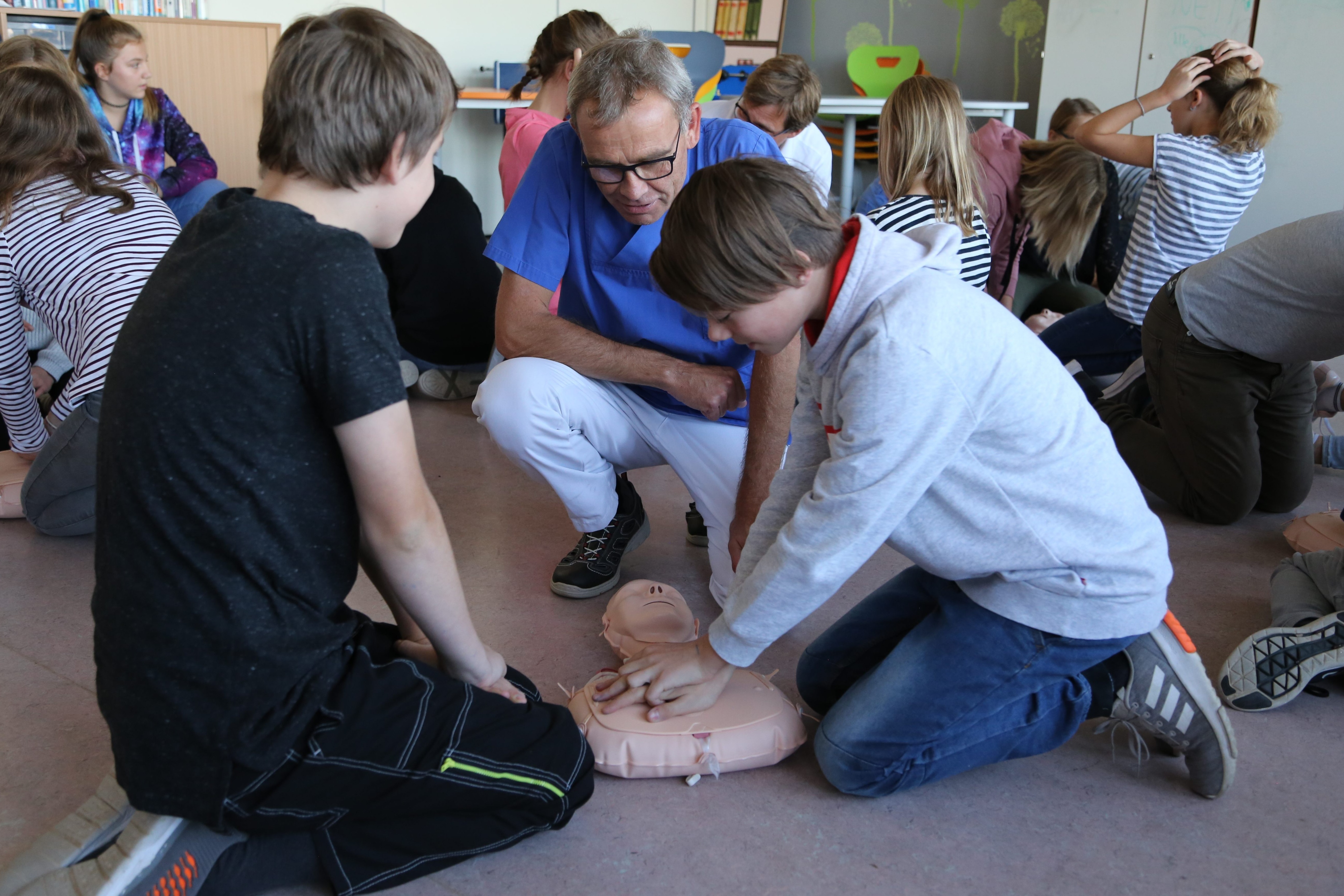 Peter Heidrich, Leitender Oberarzt der Anästhesie am Ortenau Klinikum in Oberkirch, erläutert zwei Schülern die Herzdruckmassage.
