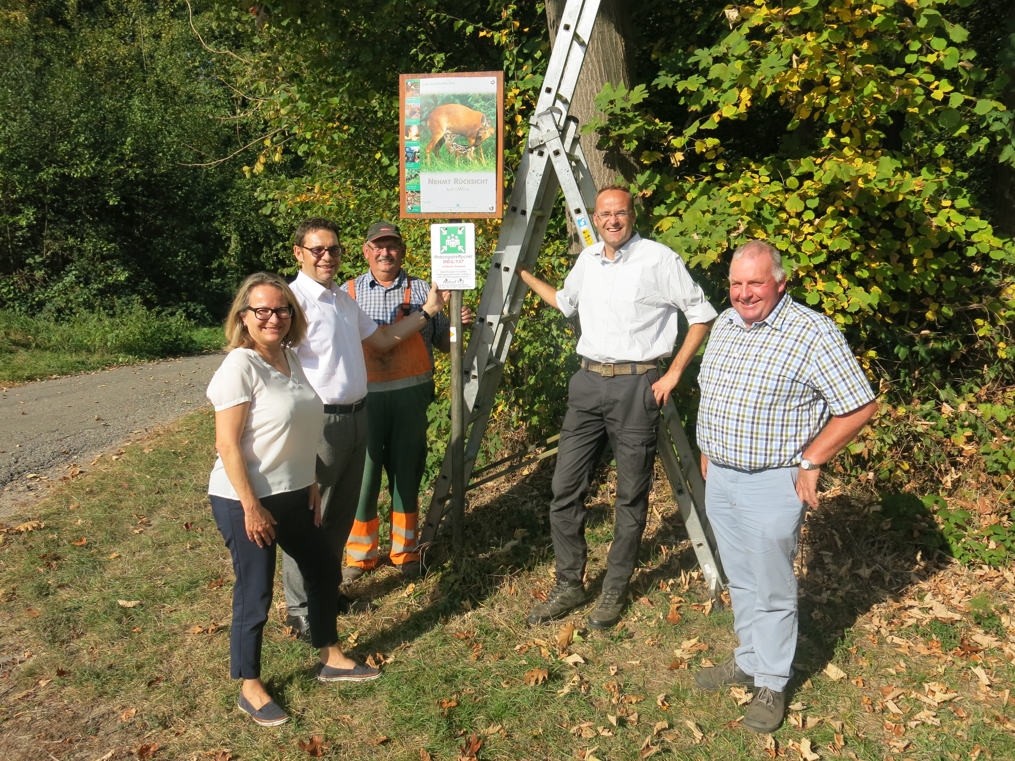Ortsvorsteherin Christine Rösch (v. l. n. r.), Oberbürgermeister Klaus Muttach, Bauhofmitarbeiter Bernd Bär, Revierleiter Markus Gutmann und Oskar Schrempp vom Fachgebiet Wirtschaftsförderung und Liegenschaften beim Aufstellen des Hinweisschildes am Grillplatz Önsbach.