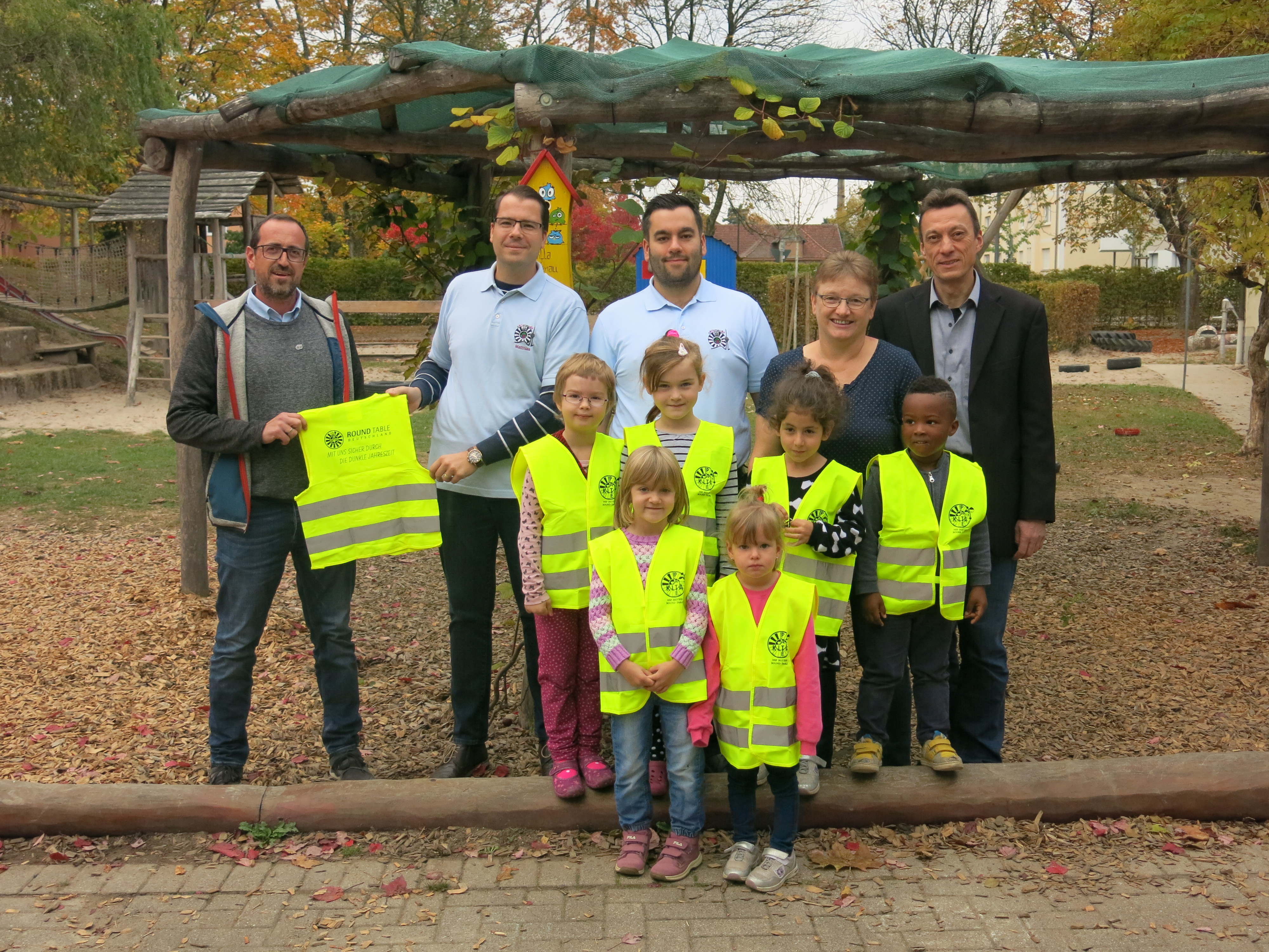 Daniel Spraul (v. l. n. r.), Matthias Krügel, Robert Haag von Round Table 85 Ortenau, Dagmar Vandersee, Leiterin der Kita Marienau und Klaus-Dieter Kramer, Leiter Fachgebiet Kindertageseinrichtungen und Soziales, präsentieren zusammen mit den Kindern die neuen Warnwesten.