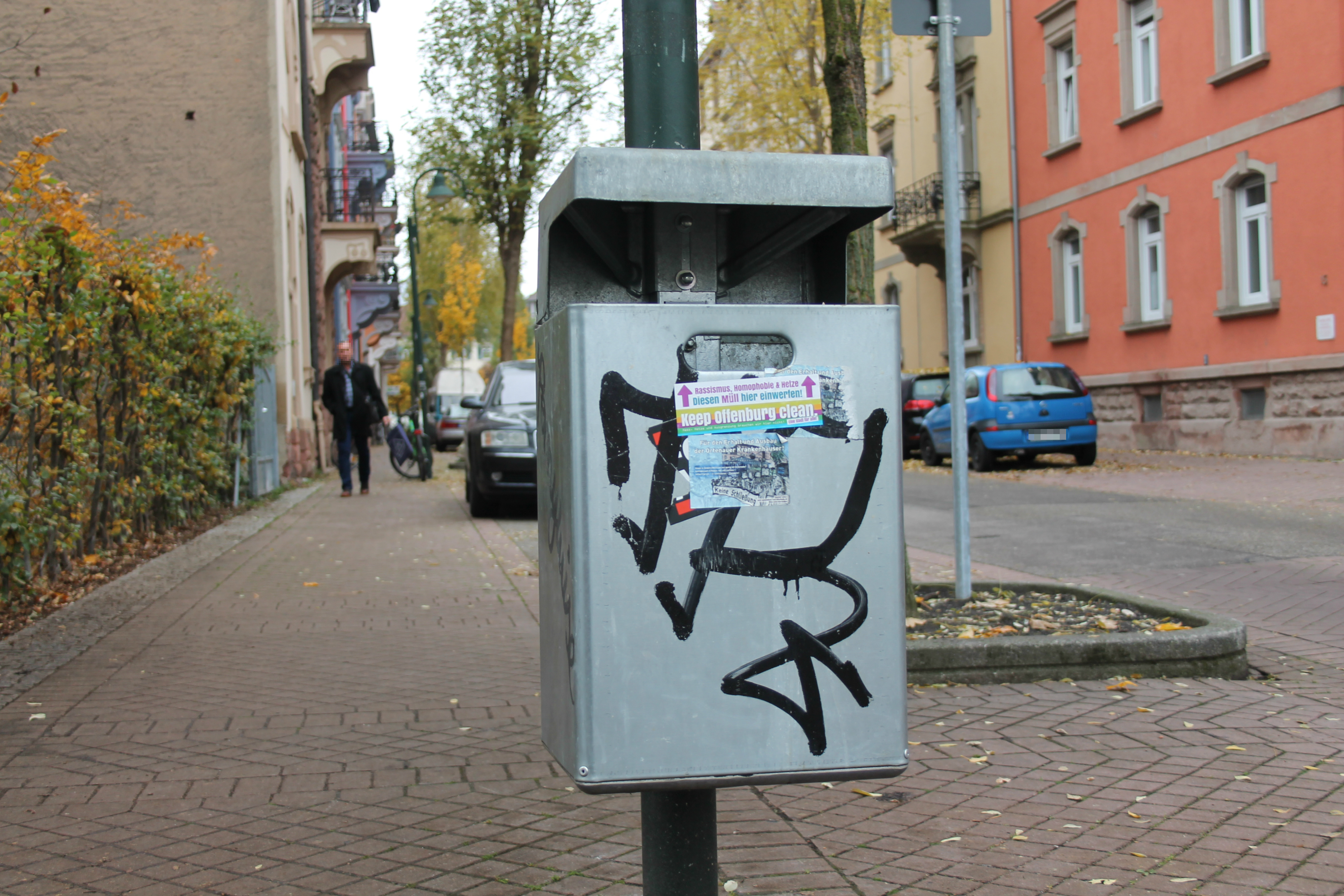 Ein Mülleimer mit Aufklebern und einem Schriftzug.