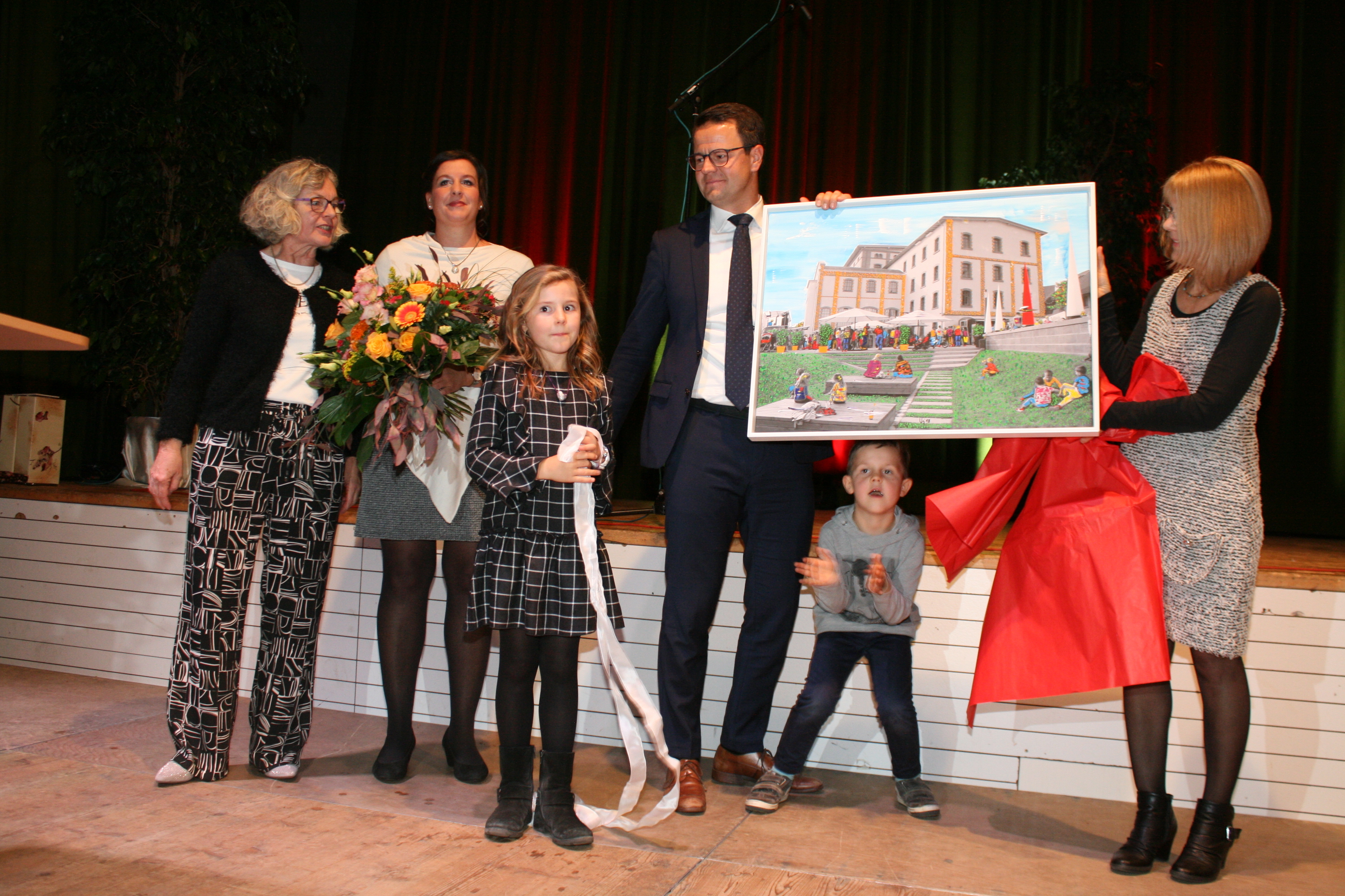 Ein Gemälde vom neuen Willstätter Rathaus zur Erinnerung für Familie Marco und Anne Steffens mit den Kindern Luisa und Elija von den Verwaltungsmitarbietern, überreicht von Elvira Walter-Schmidt (l.) und Susanne Amtsberg (r.)