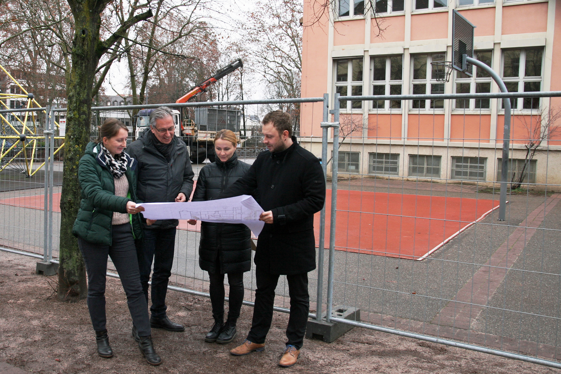 Katrin Helmchen, Abteilung Grünflächen und Umweltschutz, Klaus Keller, Abteilungsleiter Schulen und Sport, Olga Kaschnikow, Abteilung Planung sowie Andreas Kollefrath, Fachbereichsleiter Hochbau, Grünflächen und Umweltschutz vor der Georg-Monsch-Schule, die in zweieinhalb Jahren umfassend umgebaut wird.