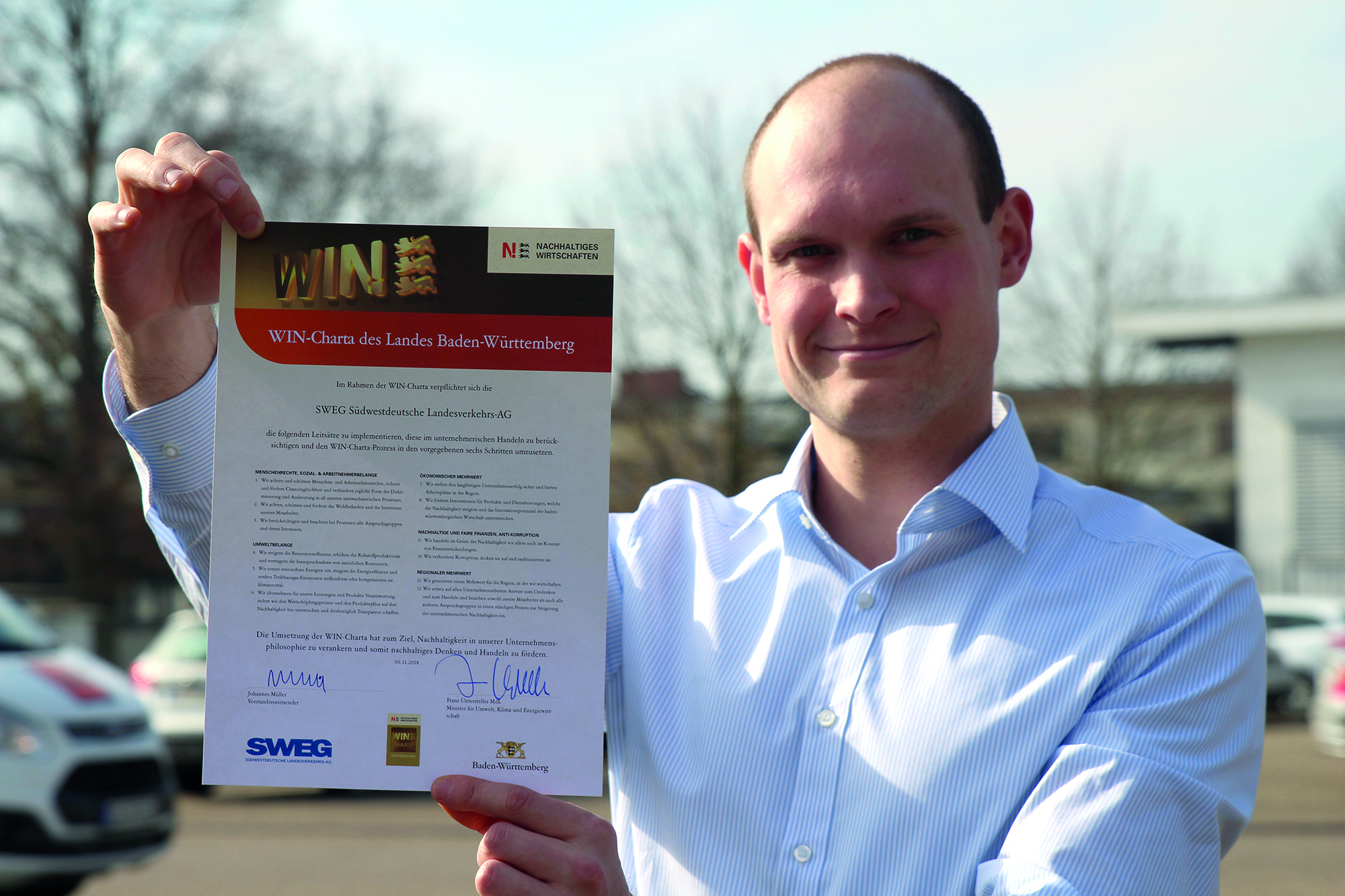 Christopher Delong, der die Nachhaltigkeitsaktivitäten im SWEG-Konzern koordiniert, zeigt die Urkunde der WIN-Charta.