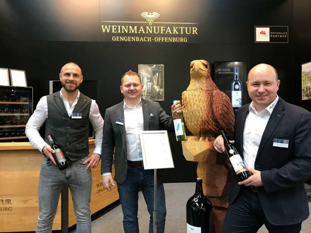 Florian Streif (v. l.), Victor Göppert – beide Vertrieb – und Christian Gehring mit dem Wappentier der Gengenbacher Weine, dem Adler auf der "Pro Wein" in Düsseldorf