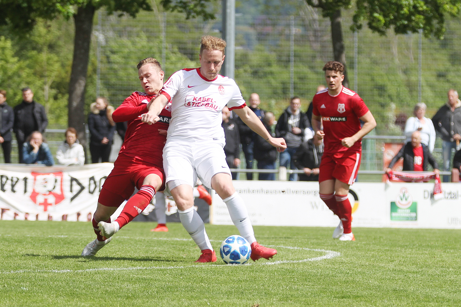 Nico Schlieter (weißes Trikot) vom Offenburger FV wird von einem Freiburger Spieler am Pass gehindert und unterlag gegen den Favoriten aus dem Breisgau.