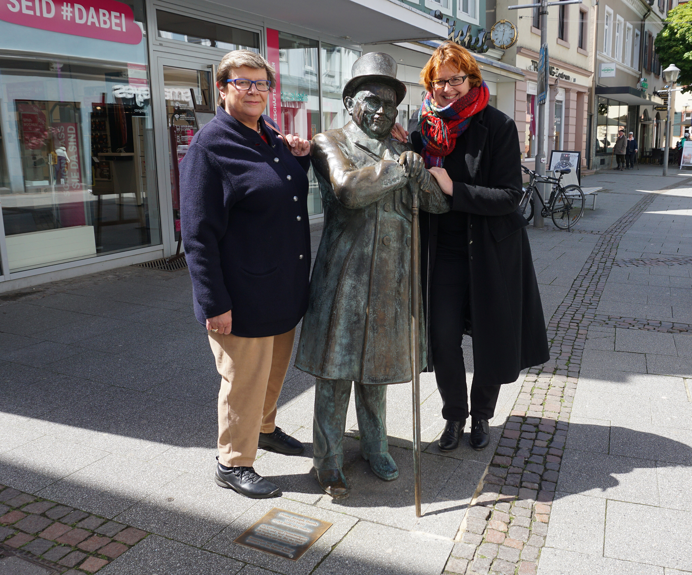 Gerlinde Brandenburger-Eisele (links) und Carmen Lötsch überprüfen, ob der Stock an der Andres-Figur hält.