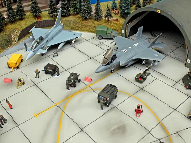 Modell eines Nato-Flugplatzes. 
Die Flugzeugtypen US-Kampfflieger F-35 und der Eurofighter.
Die Lockheed Martin F-35 Lightning II ist ein Tarnkappen-Mehrzweckkampfflugzeug, das aus dem Joint Strike Fighter-Programm des US-Verteidigungsministeriums hervorgegangen ist. 
Der Eurofighter Typhoon ist ein zweistrahliges Mehrzweckkampfflugzeug das von der Eurofighter Jagdflugzeug GmbH, einem Konsortium aus Airbus, BAE Systems und Leonardo, gebaut wird.  | Foto: Alfred Schramm