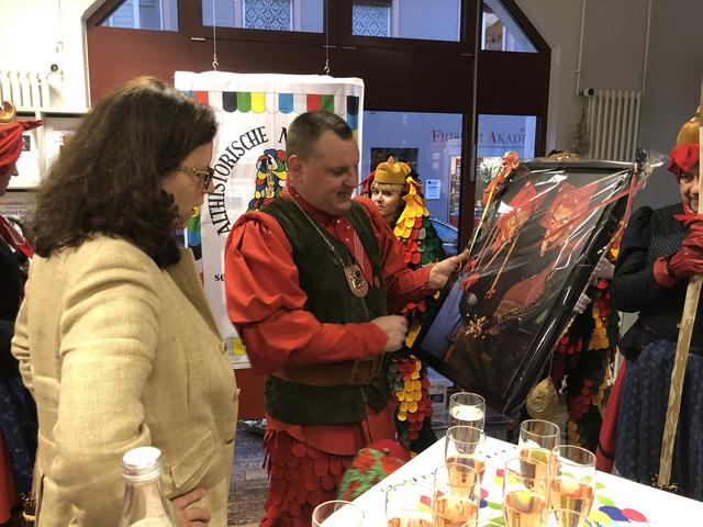 Sven Schaller übergibt Isabel Obleser ein Bild, dass zwei alte Hexenmasken zeigt. | Foto: gro