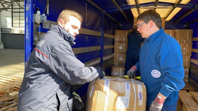 Ein Kraftakt: Jeder Karton mit Schutzausrüstung musste von den Helfern einzeln verladen werden.