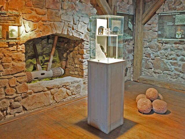 Der Eingangsbereich der sogenannten Torhalle, konnte durch ein Fallgitter geschlossen werden. Hinter diesem war noch ein Flügeltor angebracht.
Zu sehen ist die Umlenkwalze mit der das Fallgitter abgelassen und hochgezogen wurde und ein Modell in dem die Funktion eines Fallgitters zu dargestellt ist. | Foto: Alfred Schramm