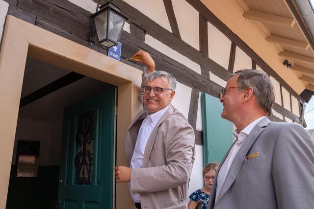 Staatssekretär Arne Braun (links) und Landrat Frank Scherer (rechts) brachten gemeinsam die Hausnummer des Ortenauhauses bei seiner Eröffnung im Freilichtmuseum Vogtsbauernhof am Sonntag, den 2. Juli, an. | Foto: Schwarzwälder Freilichtmuseums Vogtsbauernhof/Benedikt Spether