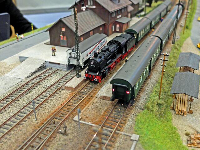 An diesem ländlichen Modell-Bahnhof halten gerade zwei Personenzüge. Die Personenwagen, sogenannte Umbauwagen der Gattung  B4yg, werden von der Dampflokomotive mit Schlepptender, der Baureihe 038 der Deutschen Bundesbahn (DB) gezogen. Die Lok- und Wagenmodell sind von der Firma Märklin. | Foto: Alfred Schramm 