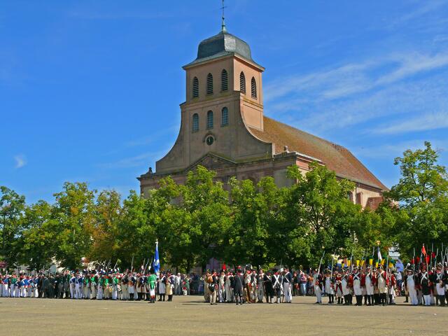Der Paradeplatz in Neuf-Brisach mit angetretenen Reenactment-Darstellern in Uniformen aus der "Napoleonische Zeit". Im Hintergrund die Kirche St. Ludwig. | Foto: Alfred Schramm