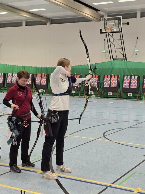 Landesmeisterin Sina Hehr, steht mit ihrem Olympischen Recurve-Bogen ,im Vollauszug- fokussiert aufs Zielen. | Foto: Celine Salrein