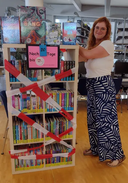 Die Leiterin der Stadtbibliothek Rheinau. Verena Kowasch, bestückt das Regel für die Aktion Heiss auf Lesen©. | Foto: Stadt Rheinau