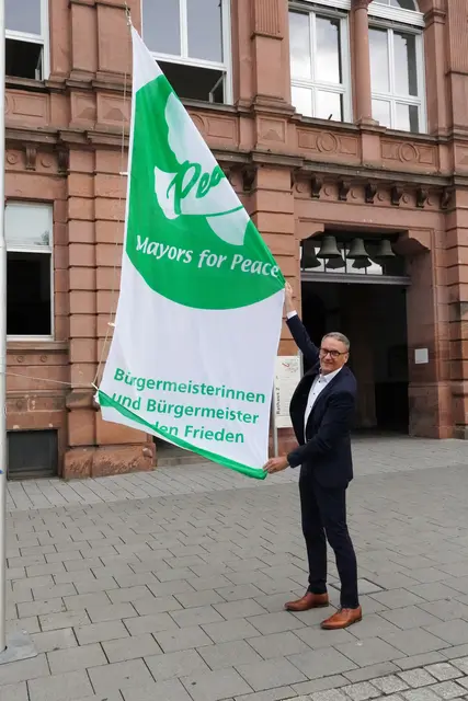 Oberbürgermeister Markus Ibert hisst die Flagge der „Mayors for Peace“ am Rathaus Luisenschule. | Foto: Stadt Lahr