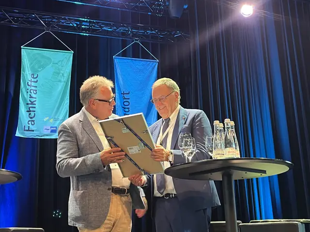 Eine Urkunde für eine 50-jährige Erfolgsgeschichte: Eberhard Liebherr überreicht diese an Roland Mack. | Foto: gro