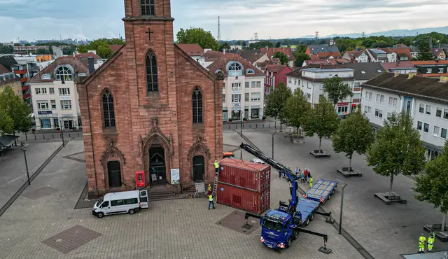 Vor der Friedenskirche auf dem Kehler Marktplatz werden zwei von insgesamt 20 Schiffscontainern für die Freiluftausstellung „Kehler Berge“ aufgestellt. | Foto: Stadt Kehl/Lardia Naba