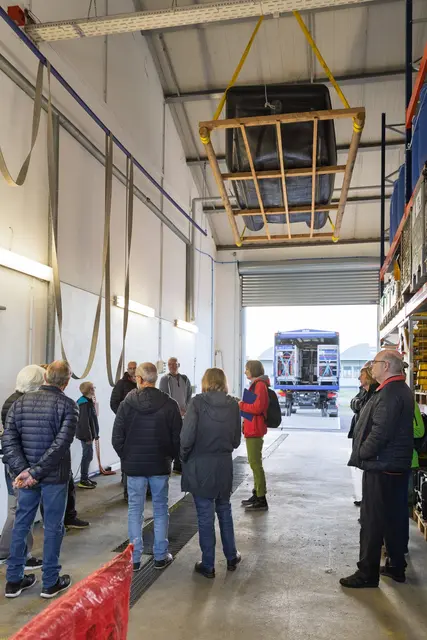 Die Interessierten des VHS-Kurses beim THW Lahr und über ihnen das schwebende Schlauchboot in der Fahrzeughalle | Foto: THW Lahr