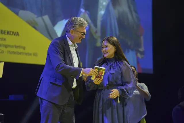 Nargiza Nurlanbekova aus Rust erhält von IHK-Hauptgeschäftsführer Dr. Dieter Salomon einen Zuschuss für ihre Reise nach Berlin. Sie und vier weitere Absolventinnen und Absolventen werden dort ein weiteres Mal von der Deutschen Industrie- und Handelskammer (DIHK) geehrt. | Foto: IHK Südlicher Oberrhein