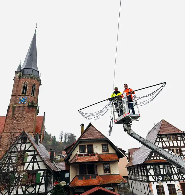 Bauhofmitarbeiter Marcel Schnurr (l.) gemeinsam mit Bürgermeister Stefan Hattenbach über der Hauptstraße von Kappelrodeck | Foto:  Gemeinde Kappelrodeck/Jasmin Liebich