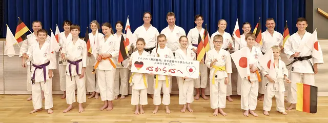 Länderflaggen als Symbol für die deutsch-japanische Freundschaft, die das Karate-Dôjô »Mukinshôri« seit vielen Jahren mit Japan verbindet. Die Vereinsvorstände John Görmann (2. v. r.) und Colin Görmann (r.) sind die Organisatoren des Hilfsprojekts »Von Herz zu Herz«. | Foto: Nadja Wojtkowiak