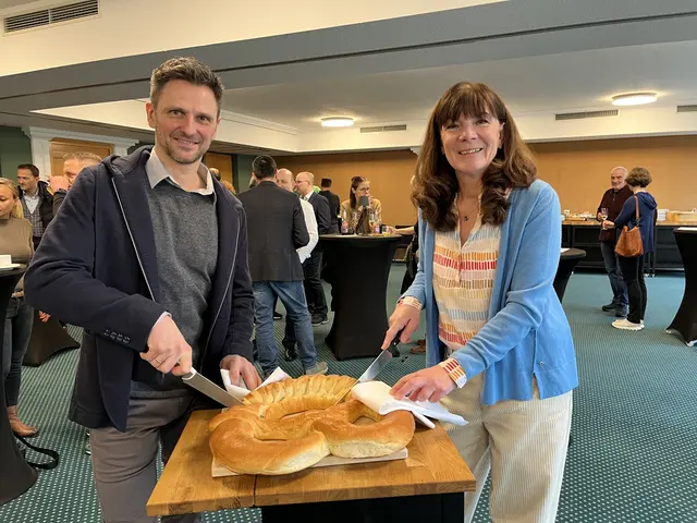 Die beiden Vorsitzenden des Gengenbacher Unternehmer Team, Michael Jülg und Andrea Andree, schneiden die Neujahrsbrezel an. | Foto: gro