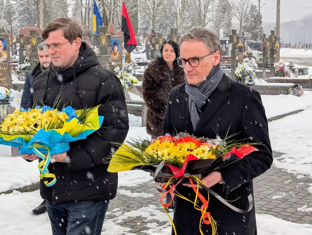 Andrii Naida und Markus Ibert (von links) legen Blumen auf dem Friedhof von Kalusch nieder. | Foto: Jonas Köhler