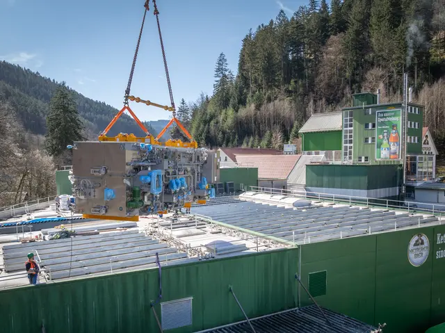 Mit einem Kran wird die rund 30 Tonnen schwere neue Flaschenreinigungsmaschine über das Dach der Abfüllhalle der Familienbrauerei Ketterer in Hornberg eingehoben. | Foto: Foto: Brauerei Ketterer