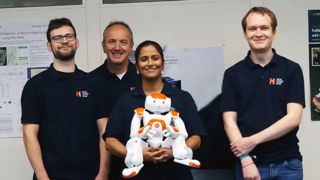 Vier der sechs mitreisenden Teammitglieder (von links) Sascha Schrempp, Klaus Dorer, Madhurshalini Mahalingam und Hannes Braun mit einem der Nao-Roboter, die früher simuliert wurden. Es fehlen Mike Benz und Simon Rösch.  | Foto: Hochschule Offenburg